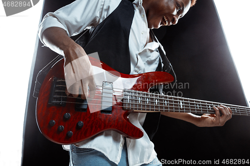 Image of African American jazz musician playing bass guitar.