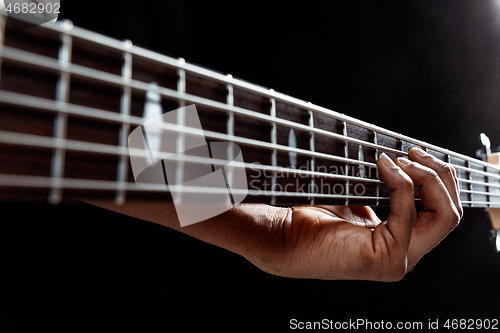 Image of African American jazz musician playing bass guitar.