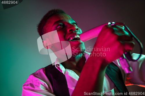 Image of African American handsome jazz musician singing.