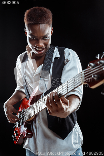 Image of African American jazz musician playing bass guitar.