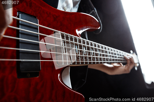 Image of African American jazz musician playing bass guitar.