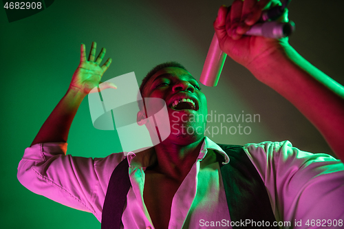 Image of African American handsome jazz musician singing.