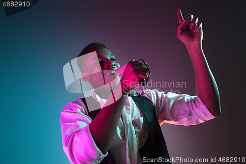 Image of African American handsome jazz musician singing.