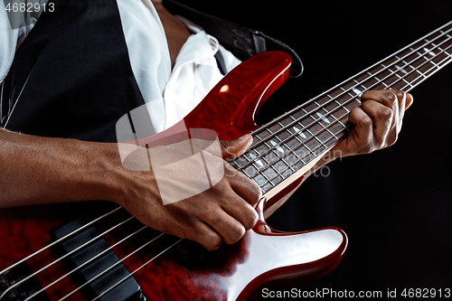 Image of African American jazz musician playing bass guitar.