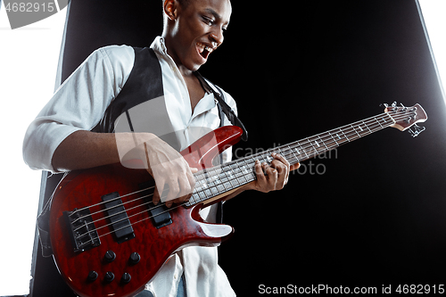 Image of African American jazz musician playing bass guitar.