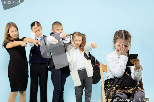 Image of Little girl sitting alone on chair and suffering an act of bullying.