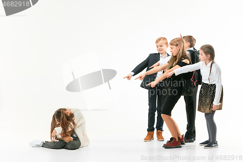 Image of Little girl sitting alone on floor and suffering an act of bullying.