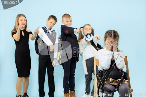 Image of Little girl sitting alone on chair and suffering an act of bullying.