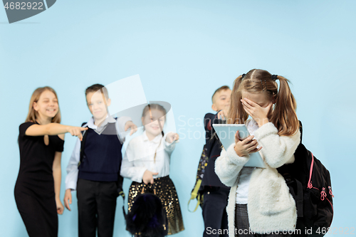 Image of Little girl standing alone and suffering an act of bullying.