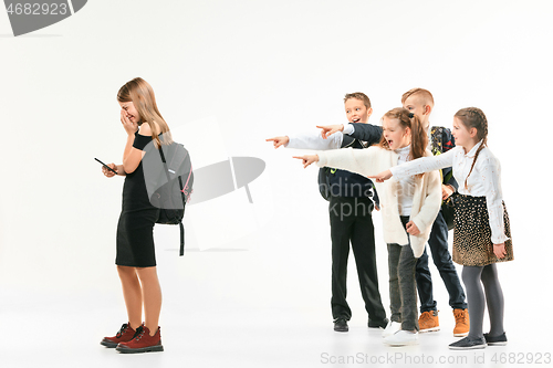 Image of Little girl standing alone and suffering an act of bullying.