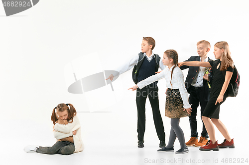 Image of Little girl sitting alone on floor and suffering an act of bullying.