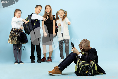 Image of Little boy sitting alone on floor and suffering an act of bullying.