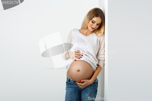 Image of Beautiful pregnant woman in jeans