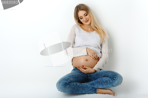 Image of Beautiful pregnant woman in jeans