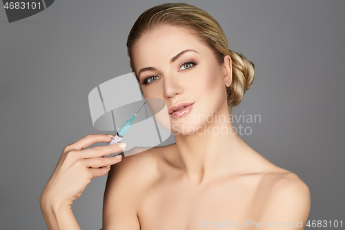 Image of beautiful girl holding syringe