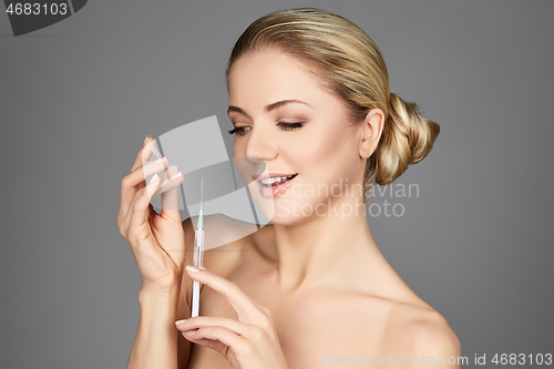 Image of beautiful girl holding syringe