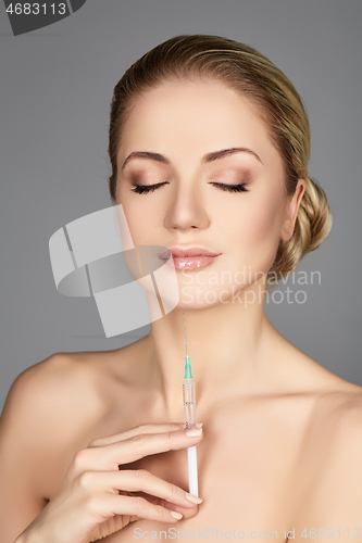 Image of beautiful girl holding syringe