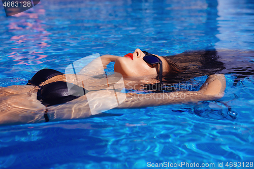 Image of Beautiful girl in outdoor pool