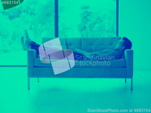 Image of Man using laptop in living room