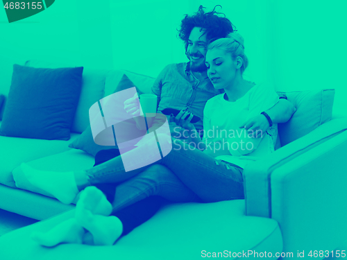 Image of Young couple on the sofa watching television