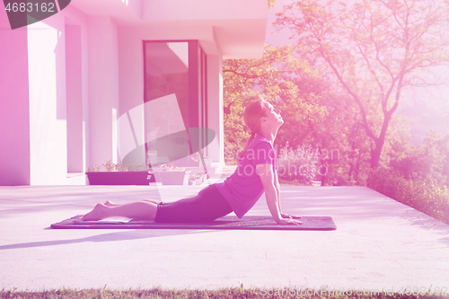 Image of handsome woman doing morning yoga exercises