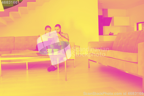 Image of romantic couple relaxing at  home with tablet computers