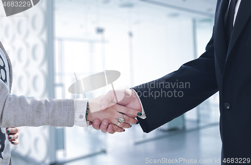 Image of Businessman and businesswoman shaking hands after meetup