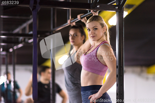 Image of young athletes doing pull ups on the horizontal bar