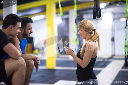 Image of athletes working out  jumping on fit box