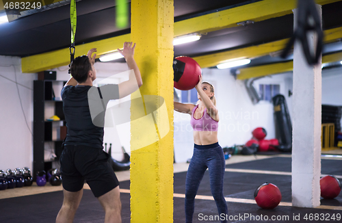 Image of young athletes couple working out with medical ball