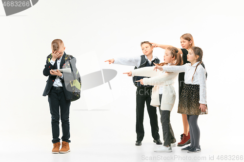 Image of Little boy standing alone and suffering an act of bullying.