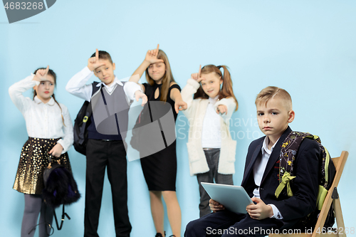 Image of Little boy sitting alone on chair and suffering an act of bullying.