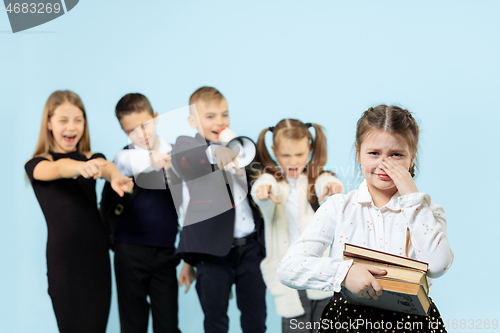 Image of Little girl sitting alone on chair and suffering an act of bullying.