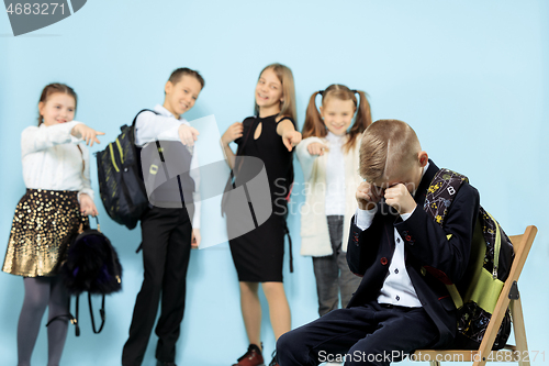 Image of Little boy sitting alone on chair and suffering an act of bullying.