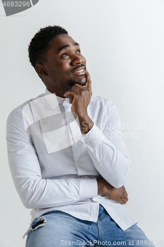 Image of Close up portrait of a happy young african american man laughing against gray background.