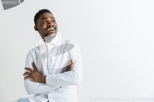 Image of Close up portrait of a happy young african american man laughing against gray background.