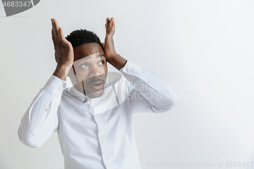 Image of Closeup portrait of handsome young man shocked surprised, open mouth and eyes, mad by what he sees, isolated on grey background. Negative human emotion facial expression feeling concept.