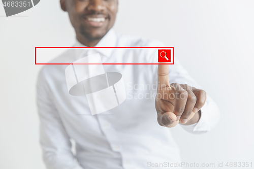 Image of Young african american guy interacts with empty search bar. Negative space to insert your text.