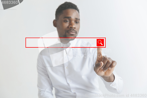 Image of Young african american guy interacts with empty search bar. Negative space to insert your text.