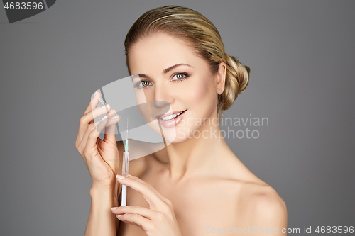 Image of beautiful girl holding syringe