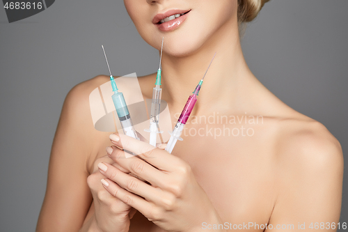 Image of beautiful girl holding syringes