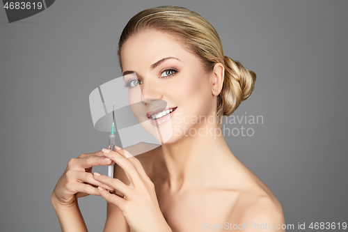 Image of beautiful girl holding syringe