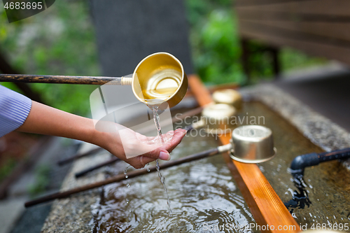 Image of Woman washing hand in water fountain