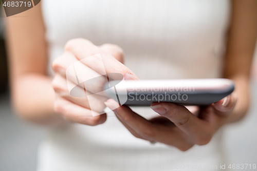 Image of Close up of woman sending sms on cellphone