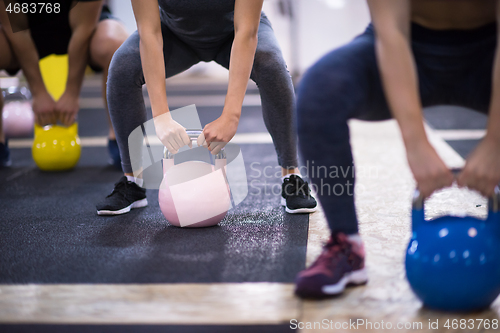 Image of athletes doing exercises with kettlebells