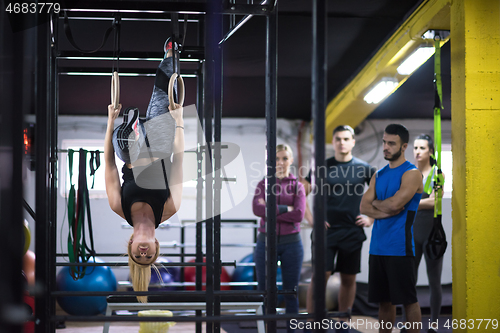 Image of woman working out with personal trainer on gymnastic rings