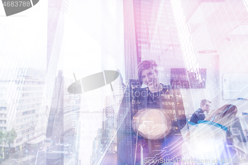 Image of Elegant Woman Using Mobile Phone by window in office building