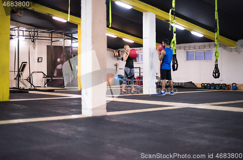 Image of young athletes couple working out with medical ball