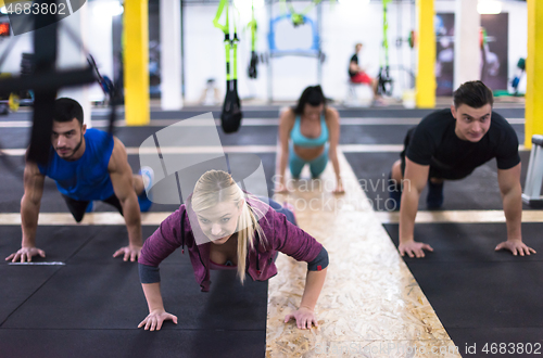 Image of young healthy people doing pushups