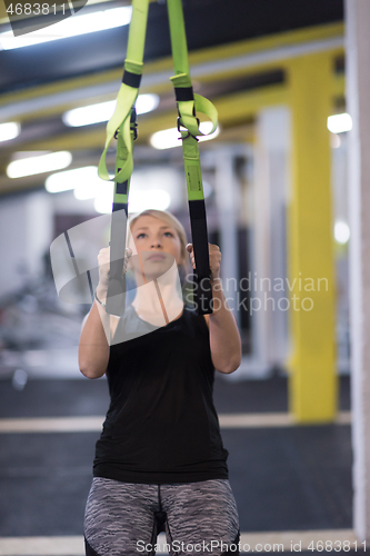 Image of woman working out pull ups with gymnastic rings